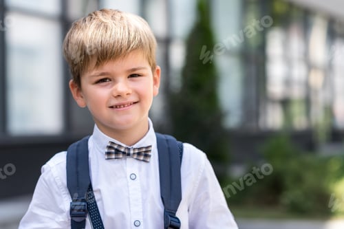 Preview: portrait of stylish cute schoolboy with backpack looking at camera