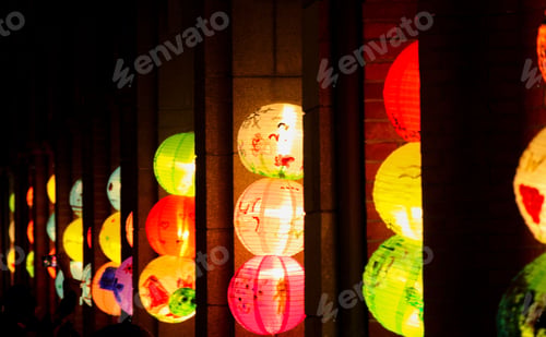 Preview: Row of colorful Chinese paper lanterns glowing in the darkness.
