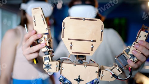 Preview: Two young engineers fixing a mechanical robot in the workshop, using VR virtual reality headsets