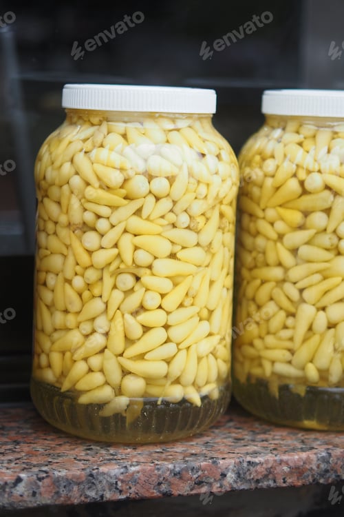 Preview: Beautifully Arranged Jars Filled with Pickled Yellow Garlic Cloves are on Display for All to See
