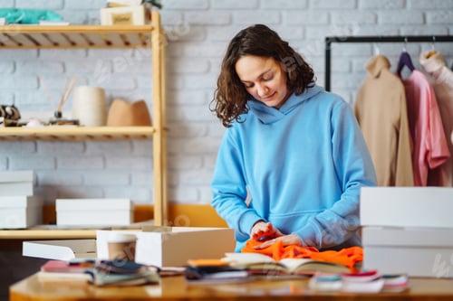 Preview: Smiling woman takes notes of orders from with laptop. Dropshipping owner works.