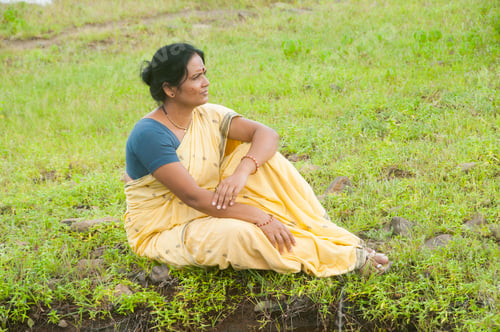 Preview: Indian woman alone in front of lake and enjoying the colors of nature.
