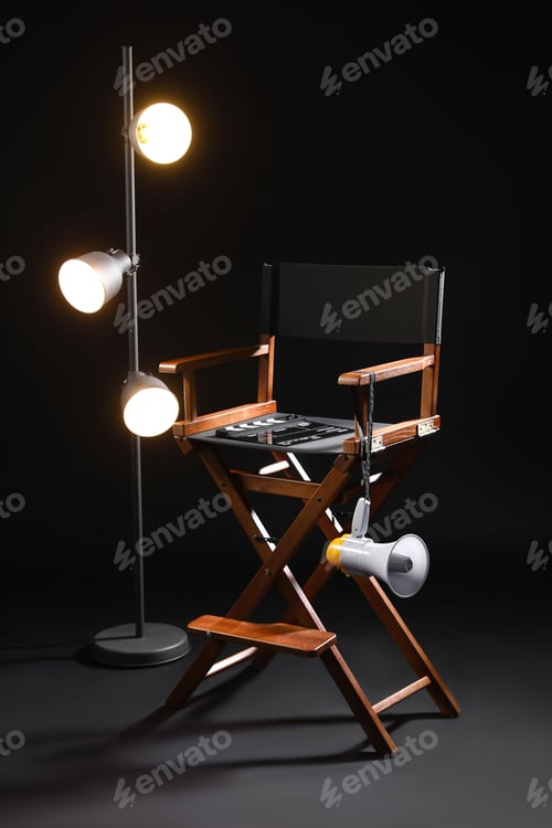 Preview: Director's chair with clapperboard, megaphone and lighting equipment on black background