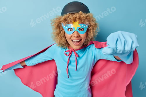 Preview: Horizontal shot of powerful female superhero makes flying gesture dressed in costume with cloak read