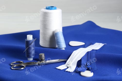 Preview: Composition with different sewing supplies on blue fabric