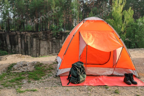 Preview: Camping tent and accessories in wilderness on summer day