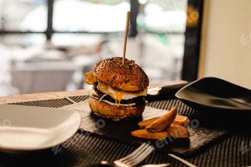Preview: Burger with egg and fries served on restaurant