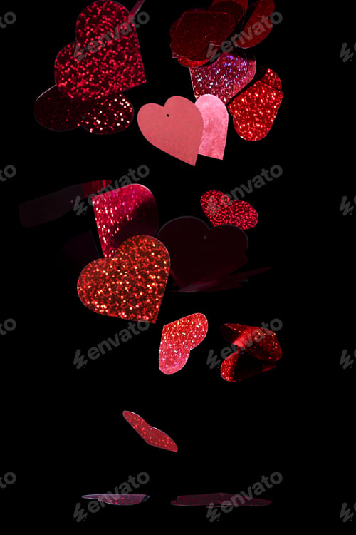 Preview: Closeup glittery, red cutout hearts against a black background - Valentine's theme background