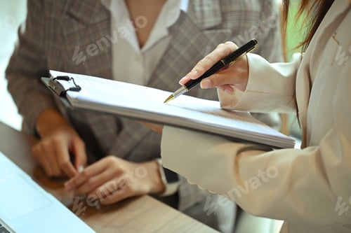 Preview: Two businesswomen wearing formal suit analyzing financial documents in the office