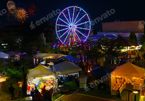 Preview: Rooftop view of a small town festival with a Ferris Wheel and fireworks in the background.