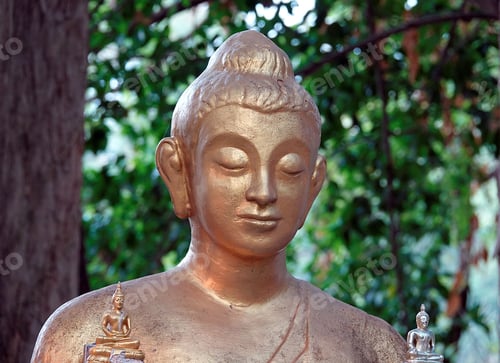 Preview: Bronze Buddha statue prominently displayed in a tranquil outdoor setting