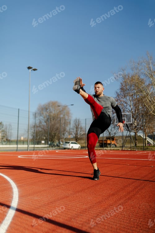 Preview: Young fit man doing exercise outside.