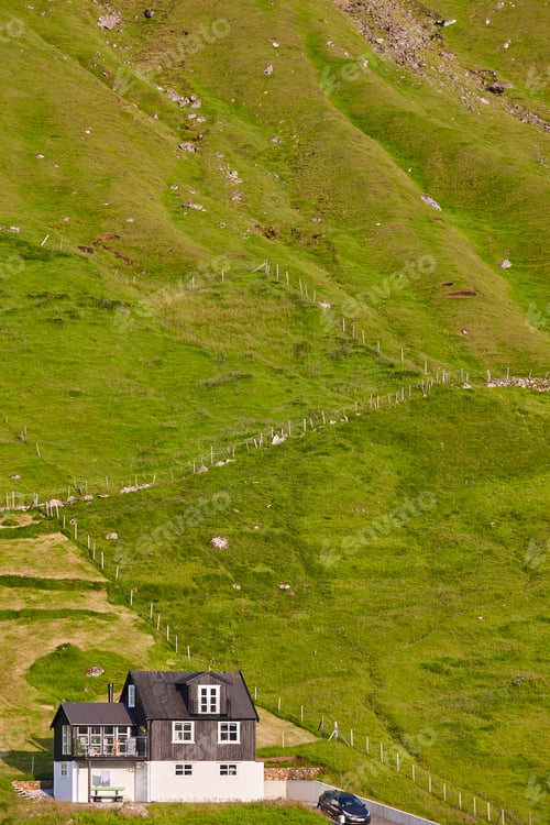 Preview: Faroese islands green landscape with traditional black wooden house. Denmark
