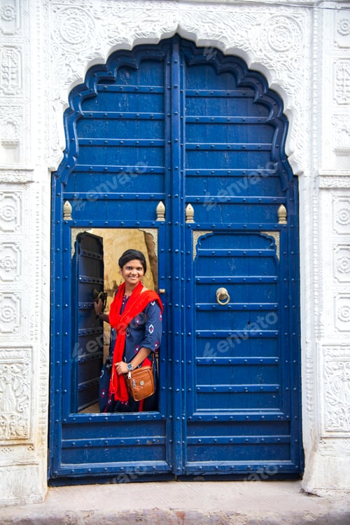 Preview: Portrait of young woman in front colorful old door, Jodhpur, Rajasthan, India