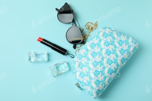 Preview: Cosmetic bag and female accessories on blue background