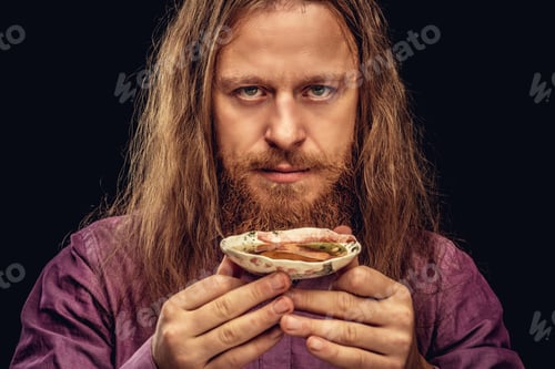 Preview: Happy redhead hipster male with holds a small saucer with tea, looking at a camera