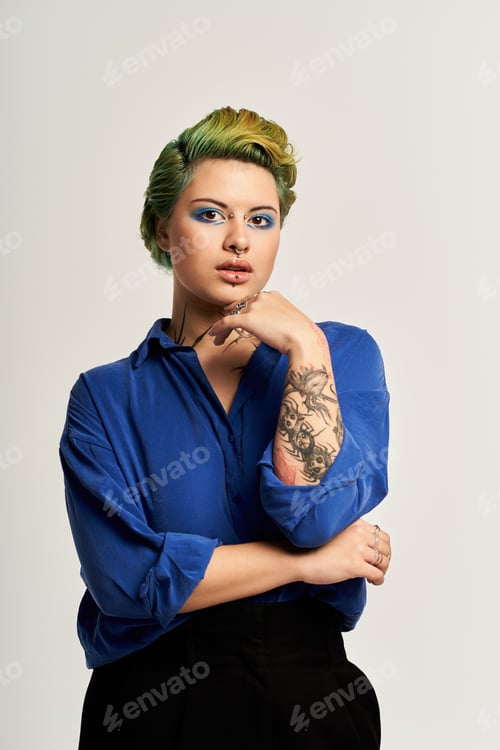Preview: Vibrant young woman showcasing bold fashion choices and striking makeup in a studio environment