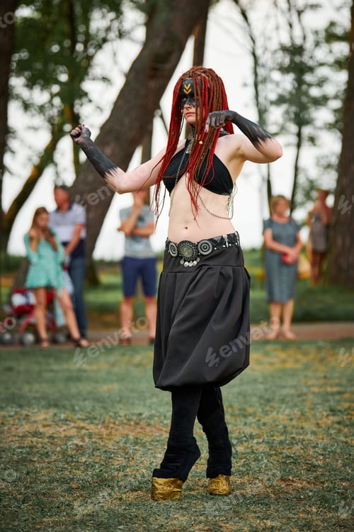 Preview: Mythological dancing girl faun on green lawn in public park outdoor art dancing event