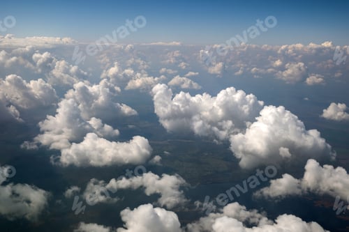 Preview: Aerial view from airplane window of white puffy clouds on bright sunny day.