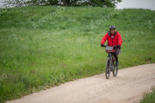 Preview: Older man cycling through the countryside