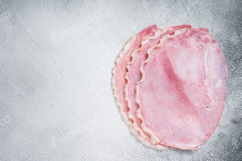 Preview: Fresh pork ham slices on kitchen table. White background. Top view. Copy space