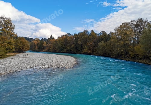 Preview: Blue river surrounded by fall colored trees.