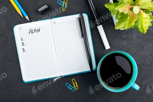 Preview: top view cup of tea plan written on notebook yellow and blue pencils black pen and marker pencil