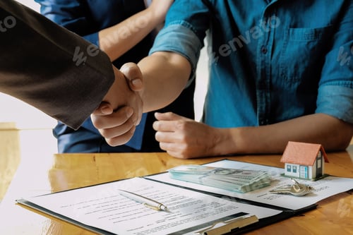 Preview: Above view of married couple and friendly realtor shaking hands after making real estate deal