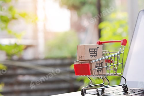 Preview: cardboard box with a shopping cart logo in a trolley on laptop keyboard