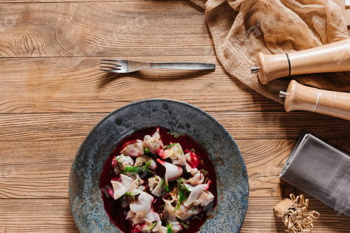 Preview: top view of gourmet Ceviche with dorado and spices on wooden table