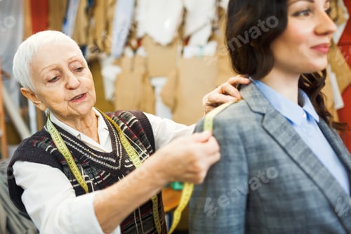 Preview: Dressmaker Fitting Jacket on a Woman in Studio