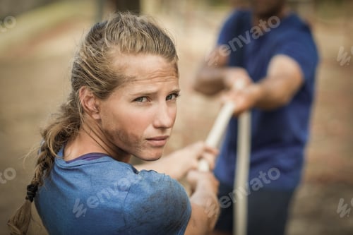 Preview: Man and woman playing tug of war during obstacle course