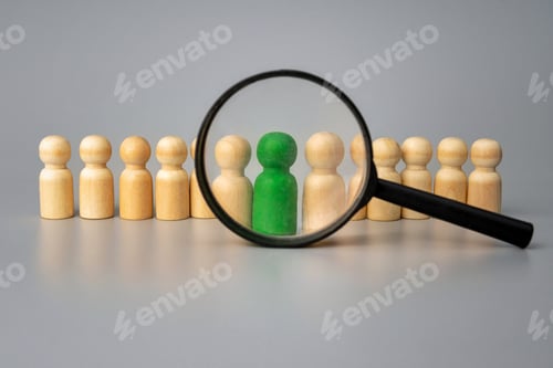 Preview: A magnifying glass and a row of wooden figures, with a green figure standing out from the others.