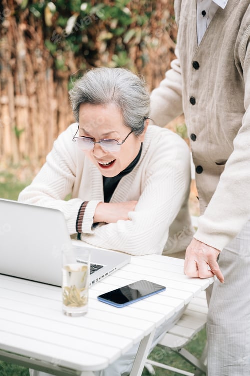 Preview: Senior Woman Using Laptop with Partner Outdoors