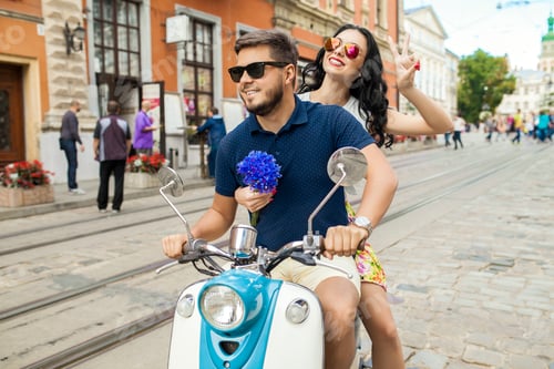 Preview: young beautiful hipster couple riding on motorbike city street