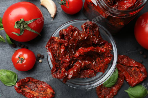 Preview: Tasty sun dried tomatoes, fresh vegetables and peppercorns on black table, flat lay