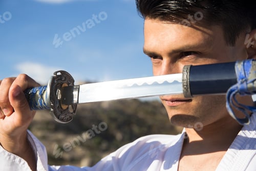 Preview: Man with defiant eyes drawing his katana sword