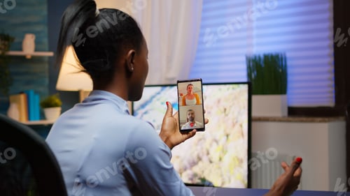 Preview: Black young lady discussing on webcam with family using smartphone