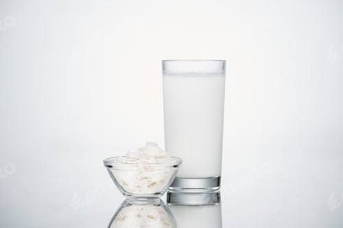 Preview: coconut vegan milk in glass near bowl with coconut slices on grey background