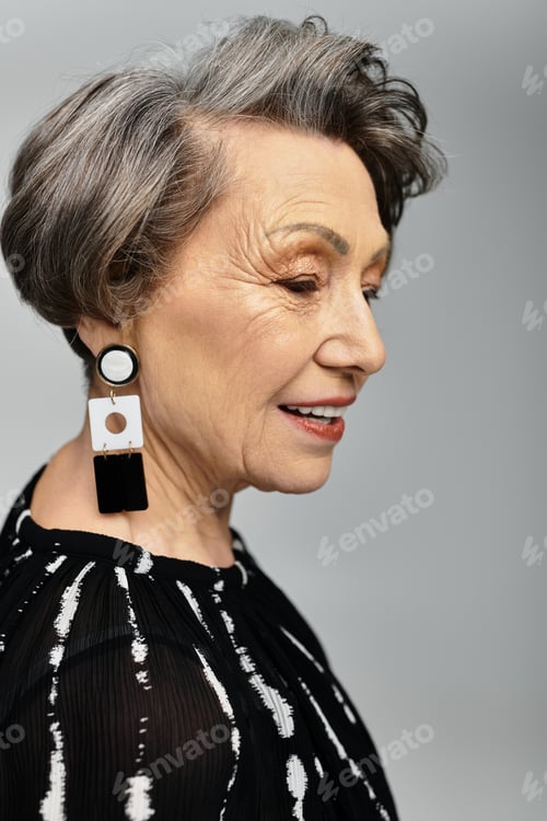 Preview: A beautiful woman in her 60s poses elegantly, dressed in stylish attire with a chic hairstyle.