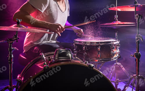 Preview: The drummer plays the drums. Beautiful blue and red background, with rays of light.