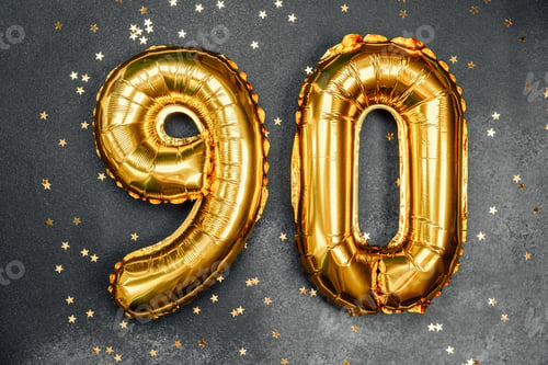Preview: Celebration of 90th birthday with golden balloons and confetti scattered