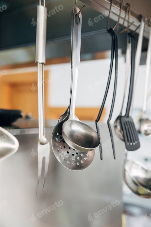 Preview: close-up shot of metallic utensils hanging at kitchen of restaurant
