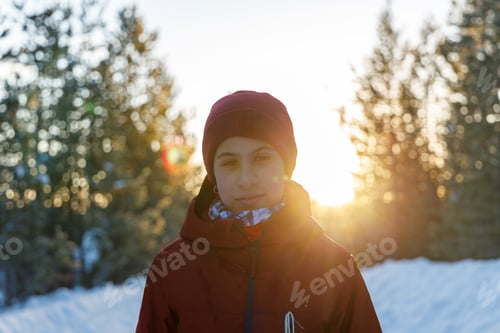 Preview: Portrait of teenage girl at winter sunset with sun shining from behind