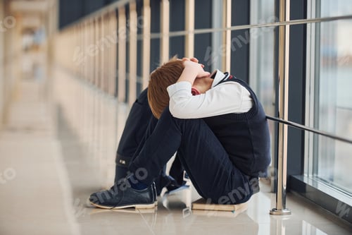 Preview: Boy in uniform sitting alone with feeling sad at school. Conception of harassment