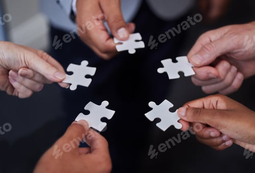 Preview: Shot of a group of businesspeople putting together puzzle pieces