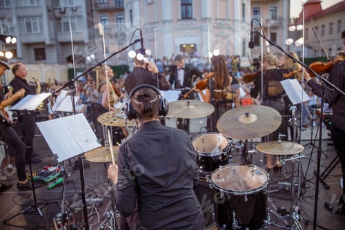 Preview: Male musician playing drums at orchestral concert outdoors