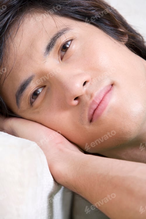 Preview: Asian man lying on a sofa