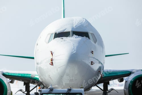Preview: Snow covered cockpit of airplane before de-icing at airport