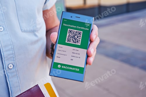 Preview: Hand with smartphone displaying on app mobile valid digital vaccination certificate for